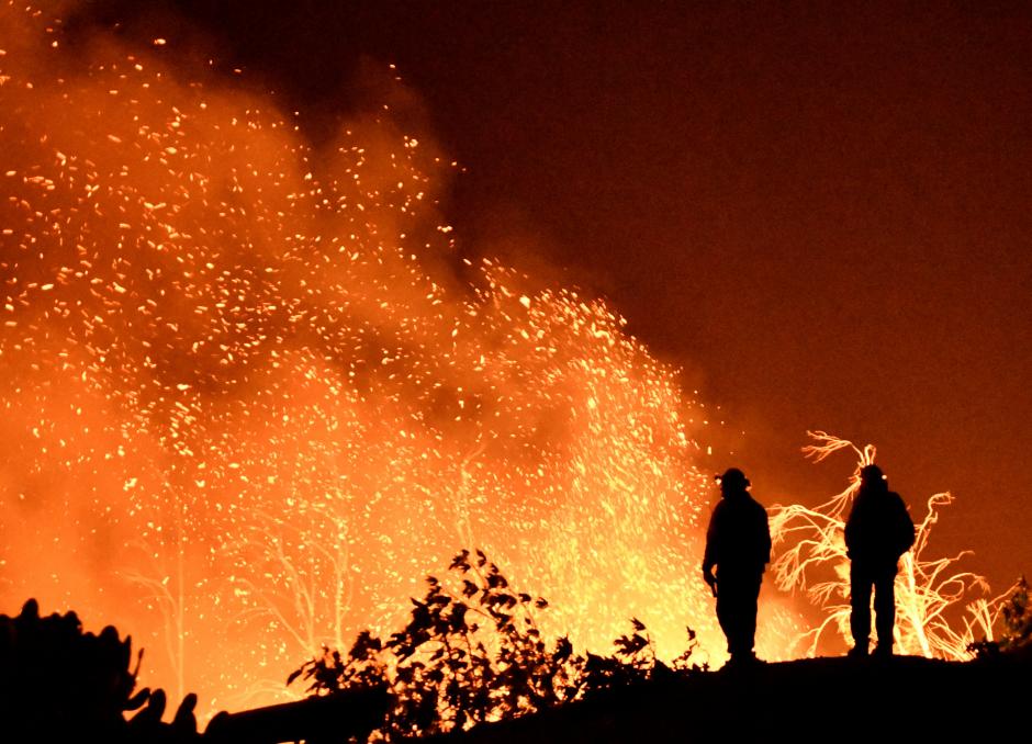 Firefighters keep watch on the Thomas wildfire in the hills and canyons outside Montecito, California